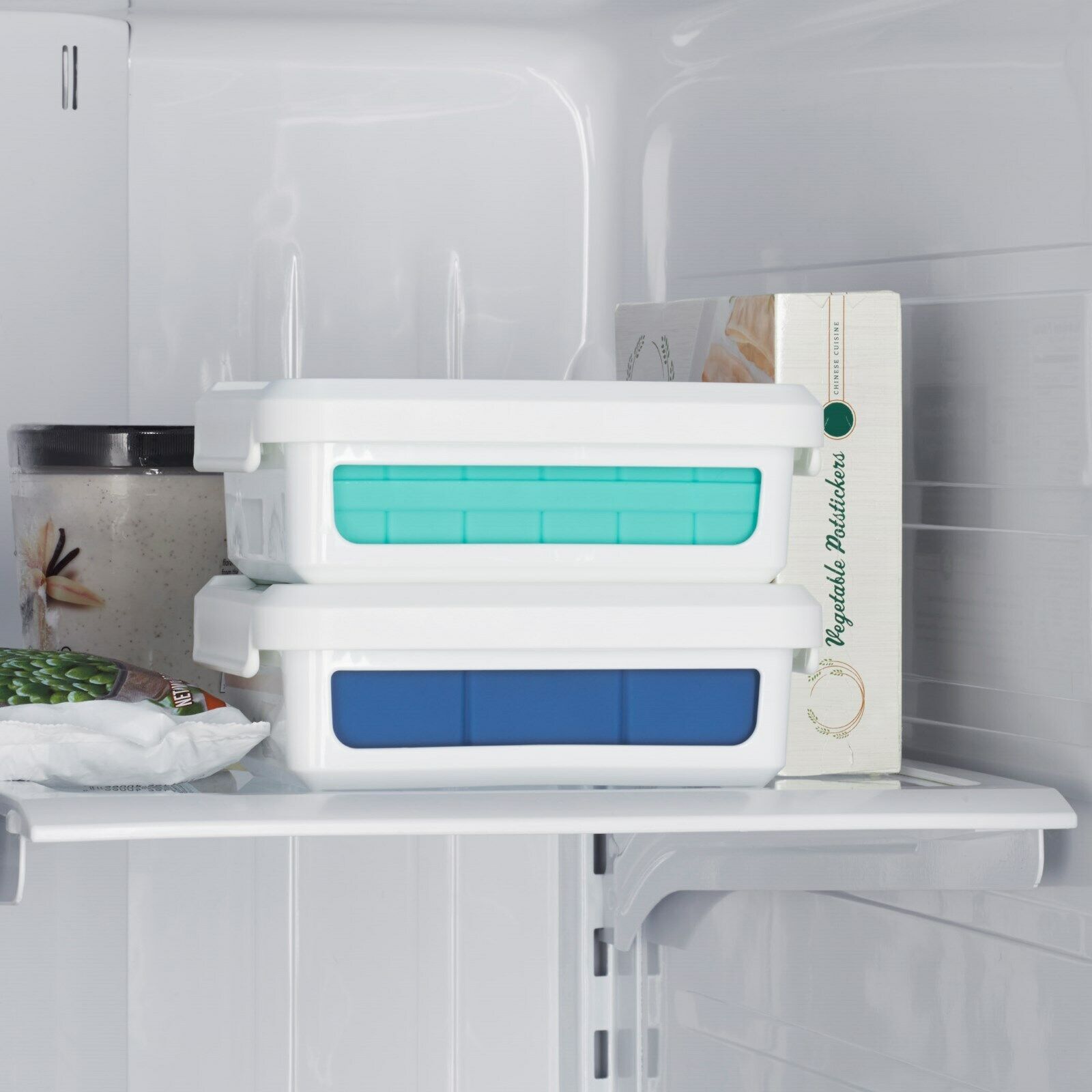 Auf diesem Bild sieht man zwei Eiswürfelbehälter aufeinandergestapelt in einem Kühlfach.